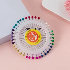 Colorful pearl head straight pins set in a round plastic tray, sewing and crafting detail view.