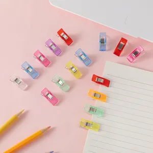 Multicolor plastic sewing clips detail view, transparent quilting clamps for fabric craft.