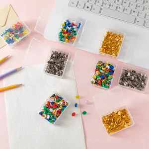 Detail view of colorful plastic and metal pushpins in transparent storage boxes, office decor.