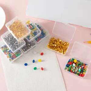 Colorful metal pushpins in transparent storage boxes for office bulletin board decoration.