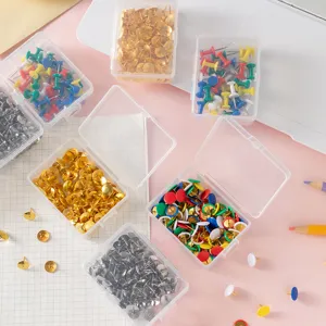 Colorful pushpins in transparent boxes, metal thumb tacks for cork board office and art display.