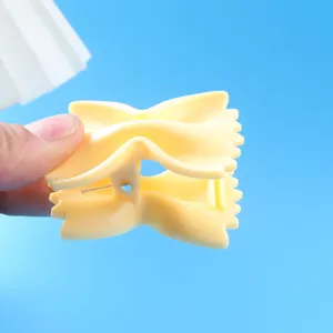 Detailopname van de gele strikclip, toont het scharnier en de fijne textuur voor dagelijks gebruik.