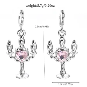 Close-up of silver candlestick earrings decorated with a shiny pink heart crystal.