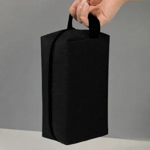 Black toiletry bag detail showing portable handle design and durable oxford fabric texture.