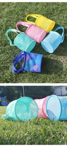 Detailed close-up view of colorful mesh beach bags on grass, perfect for outdoor toy storage.