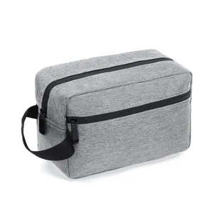 Close-up detail of the gray oxford cloth double-layer toiletry bag with black handle and zipper.