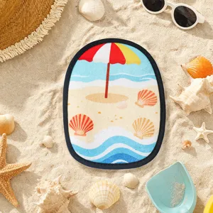Vue détail du gant de plage avec motif de parasol coloré posé sur le sable fin et chaud.