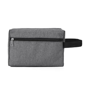 Grey toiletry bag detail showing durable fabric texture, smooth zipper, and carry handle.