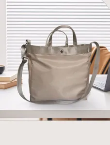 Detailaufnahme der lässigen beigen Nylontasche auf einem Schreibtisch mit robusten Griffen.