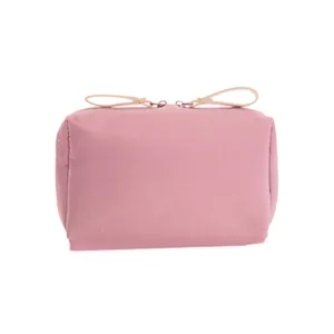 Compact pink cosmetic pouch detail, featuring durable fabric and smooth double zipper closure.