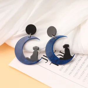 Pendientes colgantes de acrílico con luna creciente azul brillante y perrito negro.