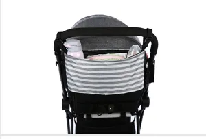 Stroller organizer bag detail showing grey striped pocket holding bottles and wipes securely.