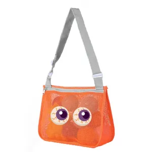 Detailed view of the orange mesh beach bag featuring fun cartoon eyeball print and sturdy strap.