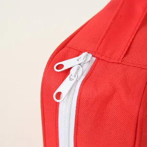 Détail de sac de rangement rouge portable montrant la fermeture éclair blanche et tissu.