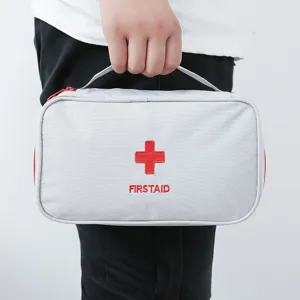 Sac de premiers secours gris portable avec croix rouge, idéal pour la maison et les voyages.