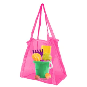 Vue détaillée du sac de plage en maille rose rempli d'un seau et d'un kit de jouets