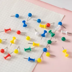 Colorful plastic head pushpins detail shot on grid paper, assorted thumb tacks for daily use
