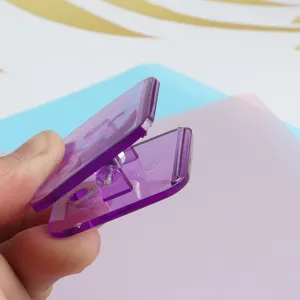 Detailed close-up of a purple transparent acrylic binder clip with strong metal spring.
