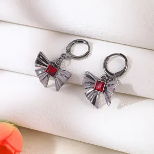 Nahaufnahme von Gothic Dark Style Schleifenohrringen mit rotem Kristall und Metall.