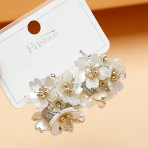 Close-up of stunning floral rhinestone earrings featuring layered white petals and sparkle.