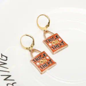 Close-up detail of Halloween trick or treat enamel bag drop earrings with gold-tone hardware.