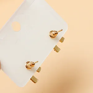 Gold tone stud earrings back detail view on white card, delicate everyday jewelry piece.