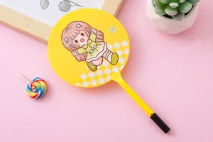 Detail shot of a yellow fan-shaped ballpoint pen featuring a cute cartoon girl illustration.