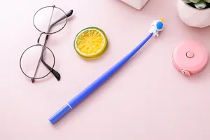 Bonito bolígrafo de gel de astronauta azul en un escritorio rosa con gafas y más
