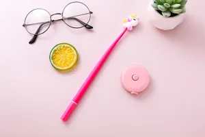 Cute pink unicorn gel pen and tape measure set on a soft pink stationery flat lay background