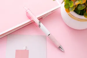 Vista macro dettagliata di una penna gel a scatto rosa e bianca minimalista per scuola e ufficio