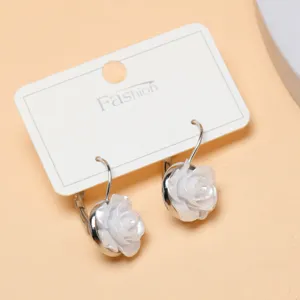 White rose drop earrings detailed view, elegant floral dangle jewelry piece on card.