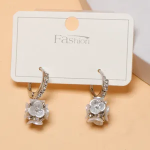 Silver tone floral drop earrings featuring sparkling rhinestones and delicate white flower charms.