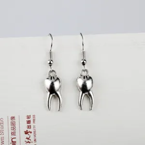 Creative funny tooth dangle earrings in silver metal hook design, quirky fashion jewelry gift.