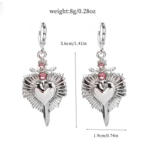 Detail shot of alloy rhinestone heart dagger earrings showing dimensions and sparkling pink stones.