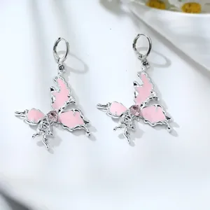 Detailed close-up of cute silver alloy drop earrings with pink crystal butterfly design.