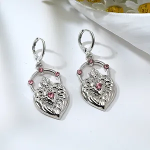 Close-up view of silver flaming heart earrings detailed with sparkling pink rhinestones.