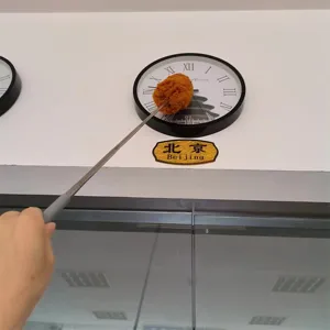 Detailed view of the extendable stainless steel ceiling duster cleaning high places.