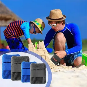Detail view of portable beach sand removal mitts in blue and grey fleece with elastic bands.