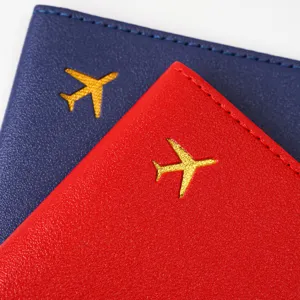 Detail shot of multi-color thick PVC leather passport cover with gold airplane stamping.