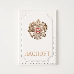 White leather passport cover with golden eagle badge and Russian text for travel documents.