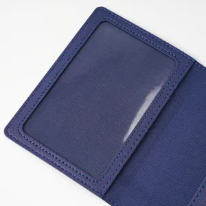 Blue passport cover detail featuring clear PVC ID window and neat stitching craftsmanship.