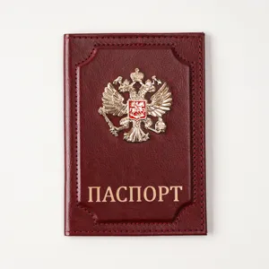 Close-up detail of the retro leather passport cover featuring a golden metallic emblem and text.