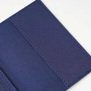 Detailed view of dark blue PVC passport holder with fine blue stitching and texture.