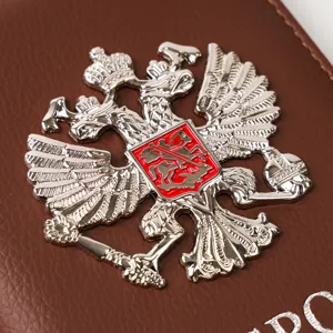 Brown PU leather passport cover featuring a metallic double headed eagle badge for travel use.