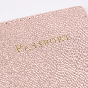 Detailed view of pink PU leather passport cover featuring gold embossed text and texture.