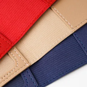 Close up detail view of textured multi-color leather passport cover stitching and grain.