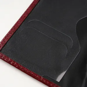 Passport cover interior detail showing transparent card slots and fine leather stitching.
