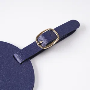 Close-up detail of a blue luggage tag strap with golden metal buckle, travel item.