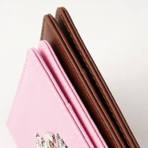 Detailed close-up shot showcasing the fine texture and metallic badge of the PU leather passport cover.