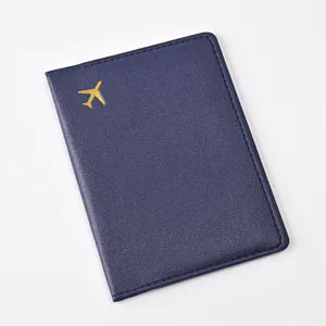 Detail shot of dark blue PU leather passport holder with golden airplane icon, smooth texture.